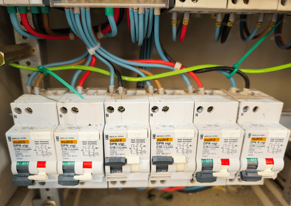Câble AS-DETECTION positionné en linéaire au-dessus des disjoncteurs d'un tableau électrique